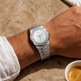Montre automatique Belvans Daylee à cadran blanc et bracelet acier portée au poignet