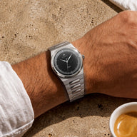 Montre automatique Belvans Daylee à cadran noir et bracelet acier portée au poignet