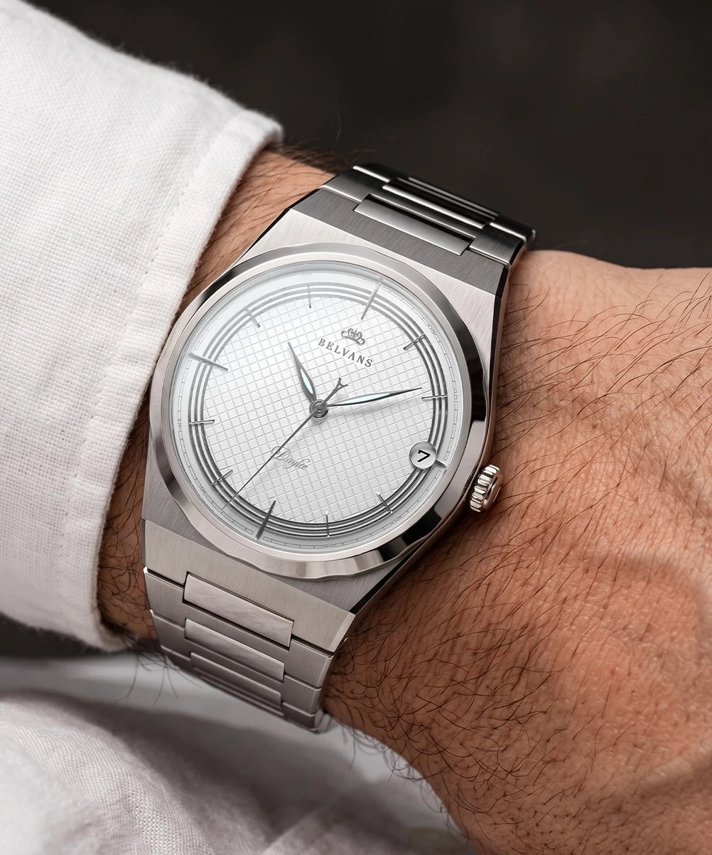 Montre automatique Belvans Daylee cadran blanc portée au poignet avec bracelet acier intégré.