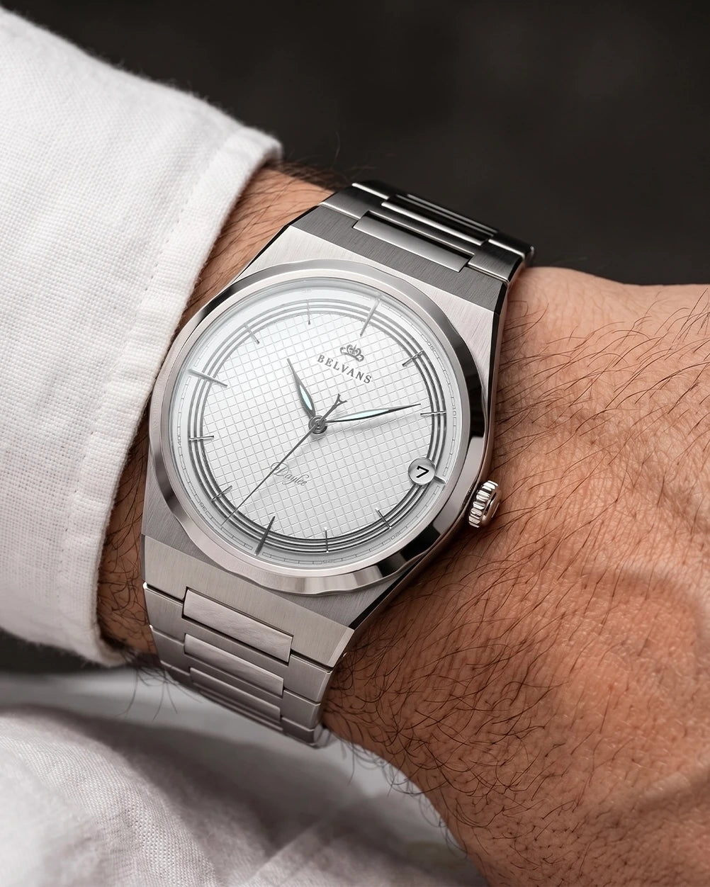 Montre automatique Belvans Daylee cadran blanc portée au poignet avec bracelet acier intégré.