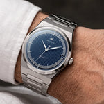 Montre automatique Belvans Daylee cadran bleu portée au poignet avec bracelet acier intégré.