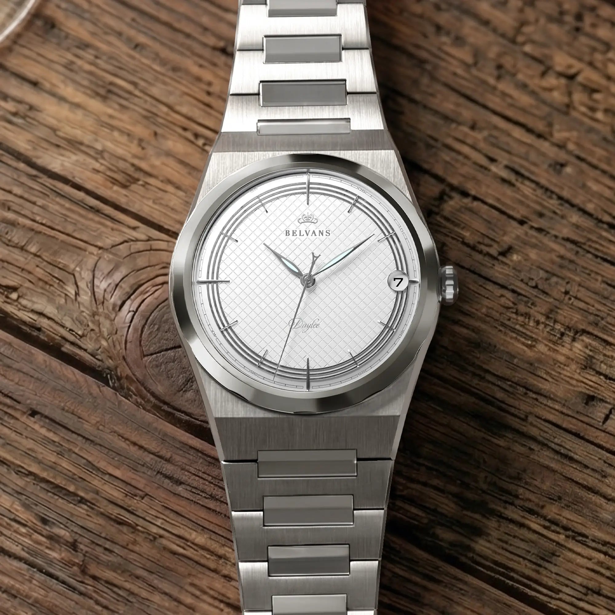 Montre Belvans Daylee cadran blanc et bracelet acier posée sur bois.