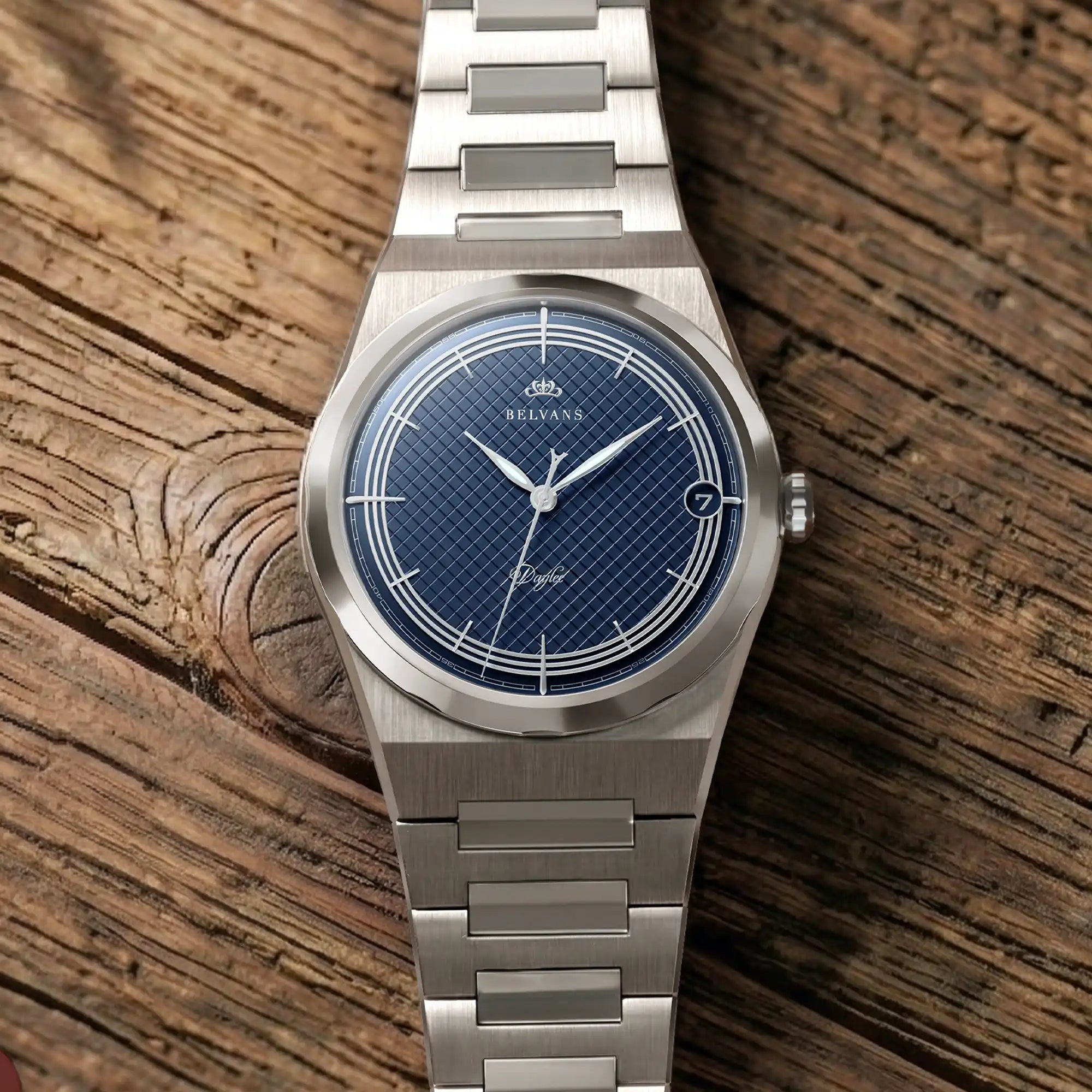 Montre Belvans Daylee cadran bleu et bracelet acier posée sur bois.