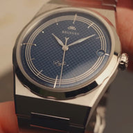 Vue macro du cadran bleu guilloché et du bracelet en acier de la montre Belvans Daylee