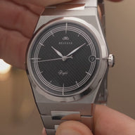 Présentation en gros plan de la montre Belvans Daylee au cadran noir et de son boîtier en acier, puis portée au poignet
